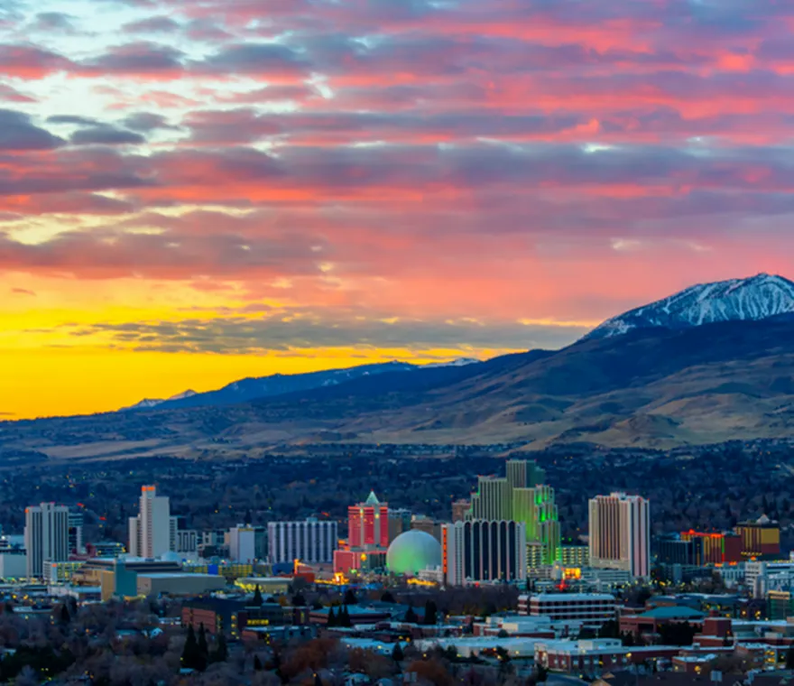 Reno Nevada cityscape at sunset with mountains